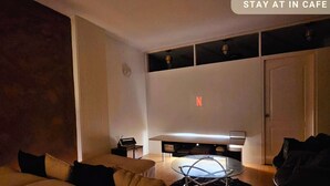 A modern living room with a sofa, a coffee table, and a TV mounted on the wall. - Cinema Stay inside Intramuros Manila by IN CAFE (Manila)