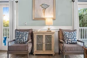 A room with two armchairs, a small cabinet, a painting, and a lamp. - Reel Time  6 BD St George Island, FL Vacation Re (St. George Island)