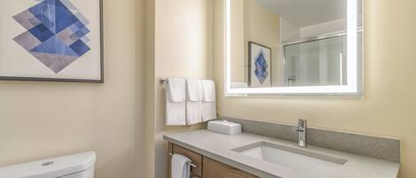 A modern bathroom with a toilet, sink, and mirror.