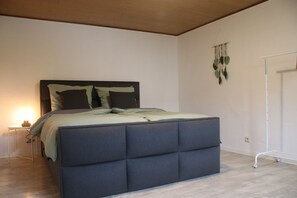 Ein Schlafzimmer mit einem großen Bett, einem Nachttisch und einer Wanddekoration.