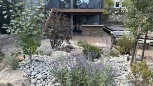 A modern house with a balcony, a stone fireplace, and a garden with rocks and plants. - Kick back and relaxing luxury home, calm western space near the Broadmoor. (Colorado Springs)