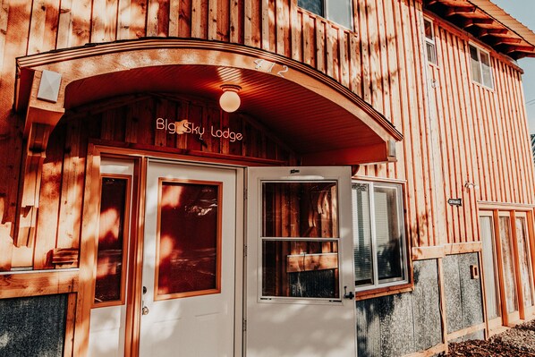 A wooden building with a sign reading "Big Sky Lodge" above the entrance. - Relax in "Big Sky" Style just 3 blocks from the Symes Mineral Soaks! (Hot Springs)
