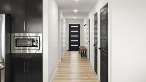A modern kitchen with black cabinets, a stainless steel refrigerator, and a built-in microwave. - New 7 bdrm home (sleeps 28) w/ lake views, sauna, hot tub, & outdoor dining! (HOLLISTER)