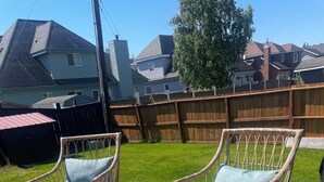 A wooden deck with wicker chairs and a small table. -  The Modern Moose. A Ranch home close to airport. (Anchorage)