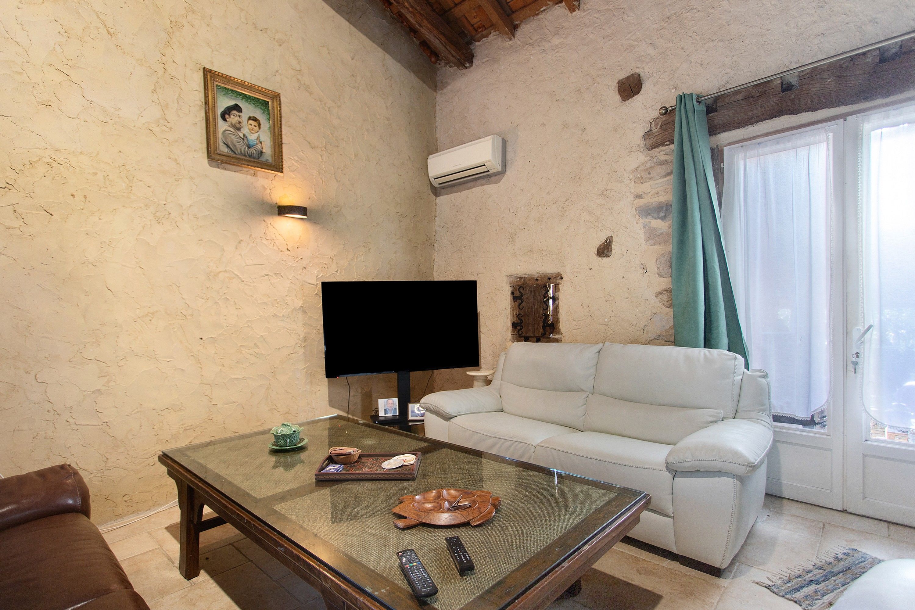 Ein Wohnzimmer mit Fernseher, Sofa und Couchtisch.
