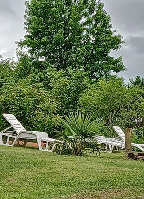 A lawn with white lounge chairs and a large tree. - Country House "Domaine Baraque" with Mountain View, Wi-Fi, and Air Conditioning (Pouillon)