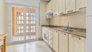 A kitchen with a stove, sink, and cabinets.