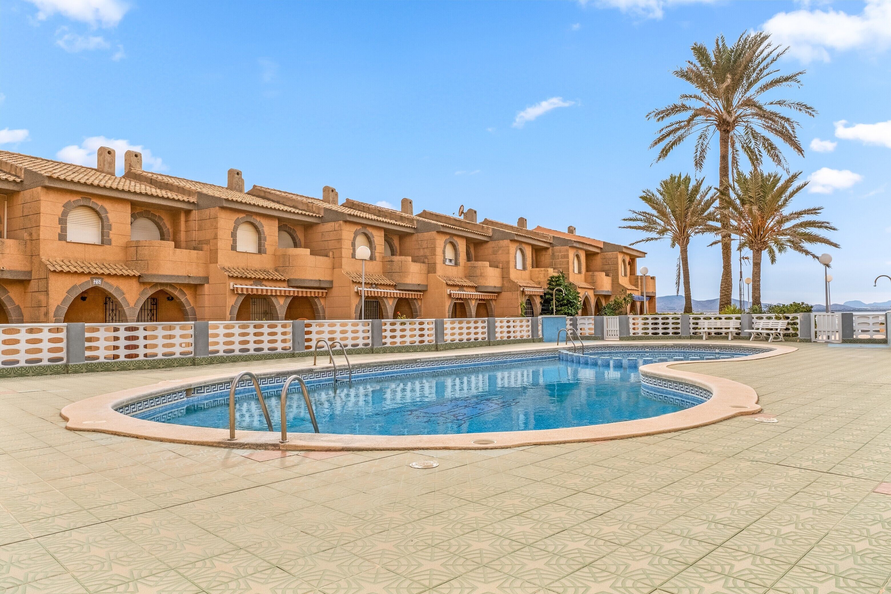 A pool area with a building in the background.