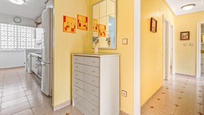 A hallway with a white dresser, a mirror, and wall art.