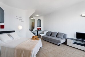 Ein modernes Hotelzimmer mit Bett, Sofa, Fernseher und einem motivierenden Zitat an der Wand.