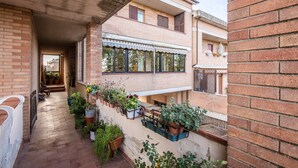 Un edificio residencial con balcón, plantas en macetas y fachada de ladrillo.
