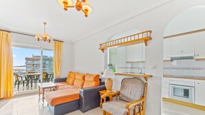 Ein modernes Wohnzimmer mit einer Couch, einem Sessel und einem Essbereich.