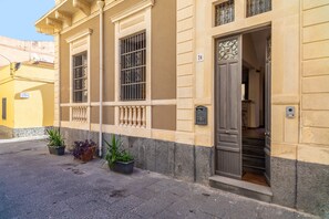 Un bâtiment doté d’une porte, de fenêtres et de plantes en pot.