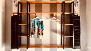 A room with a wooden rack holding clothes, two wall-mounted fans, and a tiled floor. - Holiday Home "Lola's Beach House" with Sea View, Private Pool & Wi-Fi (Calafell)