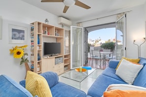 A modern living room with a sofa, TV, and open shelving. - Apartment 'Superb  Nerja' with shared pool, Wi-Fi, Air-Con, near Burriana Beach (Nerja)