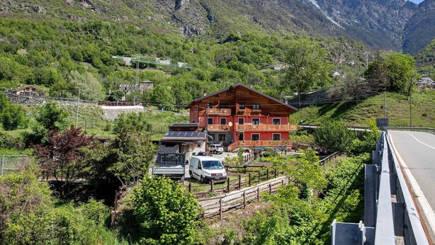 A mountain lodge with a red exterior, solar panels, and a white van parked in front. - Apartment "Casa Michod - Nonno Marcel" with Mountain View in Chatillon (Chatillon)