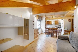 A modern interior with a wooden ceiling, a dining area with chairs, a sofa, and a kitchen with cabinets and appliances. - Apartment "Casa Michod - Nonno Marcel" with Mountain View in Chatillon (Chatillon)