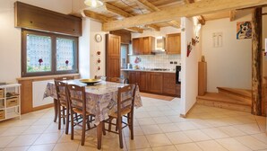 A kitchen with wooden beams, a dining table with chairs, and a window with a view. - Apartment "Casa Michod - Nonno Marcel" with Mountain View in Chatillon (Chatillon)