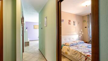 Een slaapkamer met een bed, een hoofdeinde en een muur met foto's.