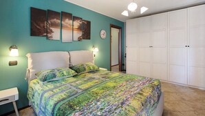 A bedroom with a bed, a nightstand, a wall clock, and a wardrobe. - Apartment "Casa Michod - Nonna Genia" with Mountain View, Shared Garden & Wi-Fi (Chatillon)