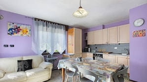 A compact living space with a kitchenette, a dining area, and a sofa. - Apartment "Casa Michod - Nonna Genia" with Mountain View, Shared Garden & Wi-Fi (Chatillon)