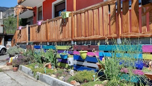 A colorful wooden fence with potted plants and a balcony. - Apartment "Casa Michod - Nonna Genia" with Mountain View, Shared Garden & Wi-Fi (Chatillon)