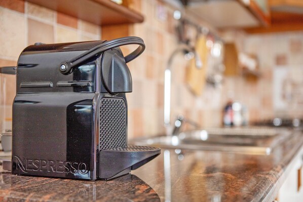 Une machine à café Nespresso posée sur un plan de travail de cuisine.
