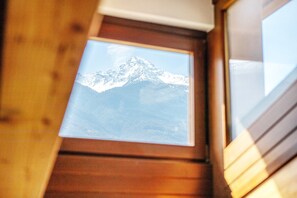 Une fenêtre donnant sur une montagne enneigée.