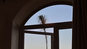 A window with a view of a sunset over a field and a tall structure. - Bhalil Farm House  (Bhalil)
