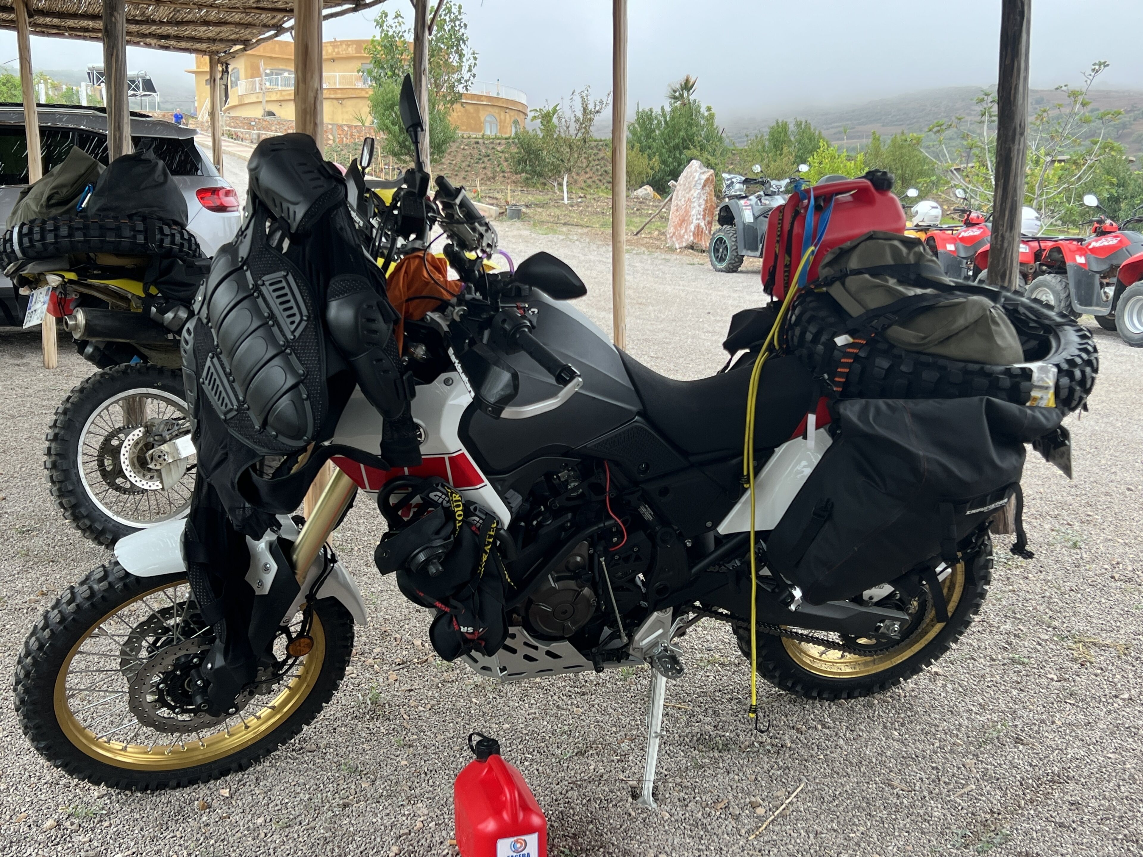 A motorcycle with a sidecar parked in a covered area with other vehicles.