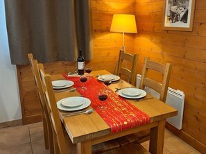 Guests can dine in comfort with a table set for four, featuring fine china and a bottle of wine.