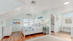 A bedroom with a bed, dresser, vanity, and a window with a view. - THE BLUE HOUSE AT OLD COLORADO INN (Stuart)