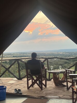 Una persona sentada a una mesa con vistas al paisaje.