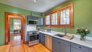 A kitchen with green walls, wooden cabinets, a stainless steel stove, and a sink. - Near Downtown Cincinnati: Peaceful Retreat! (Cincinnati)