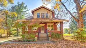 A two-story house with a brick facade, a gabled roof, and a front porch with steps leading to the entrance. - Near Downtown Cincinnati: Peaceful Retreat! (Cincinnati)