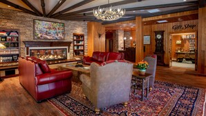 A cozy interior with a fireplace, leather sofas, a rug, and a gift shop. - Mount Lemmon Lodge (Mount Lemmon)