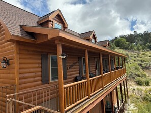 A log cabin with a wooden deck and multiple windows. - Mount Lemmon Lodge (Mount Lemmon)