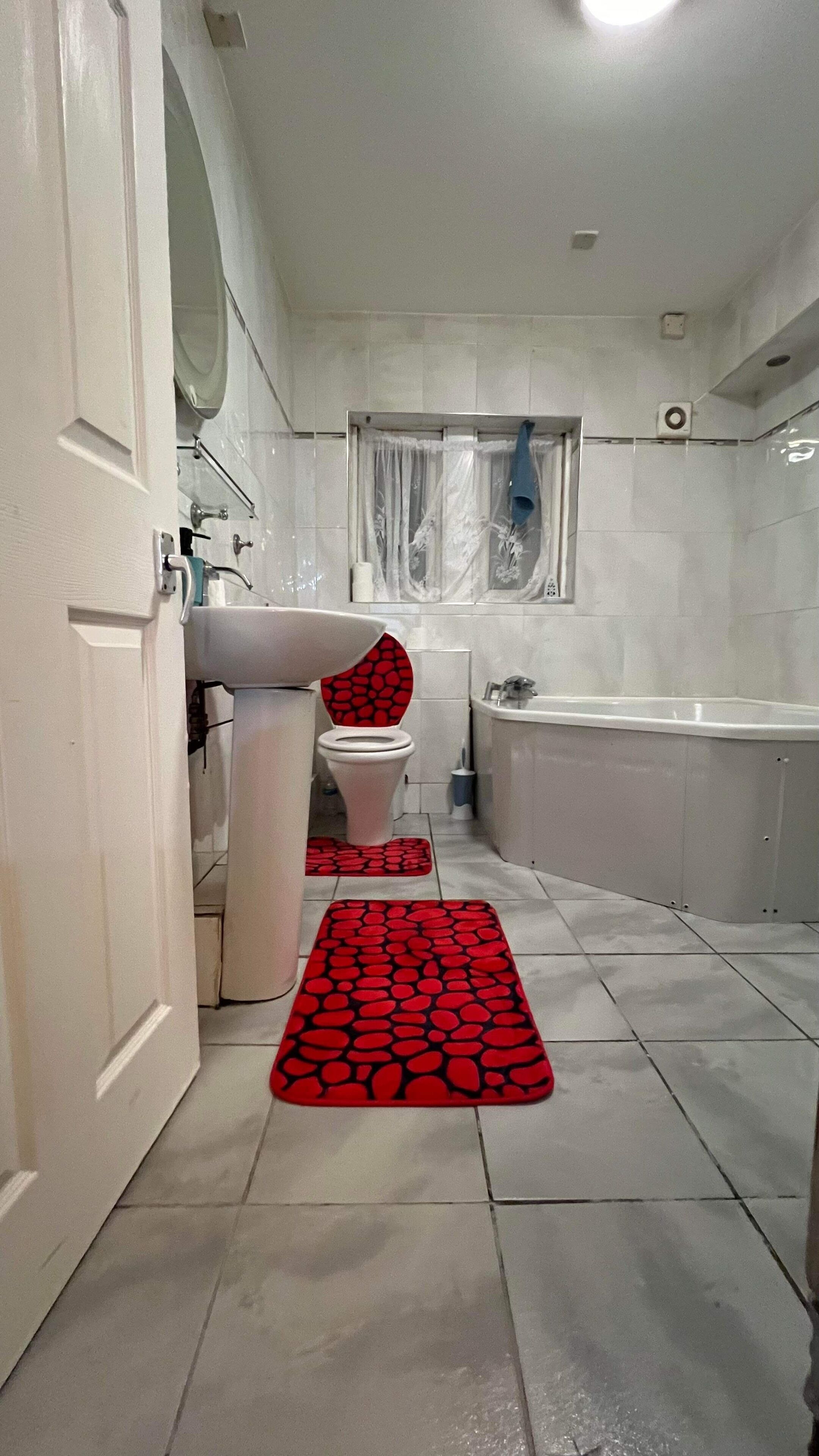 A bathroom with a toilet, sink, bathtub, and a shower area.