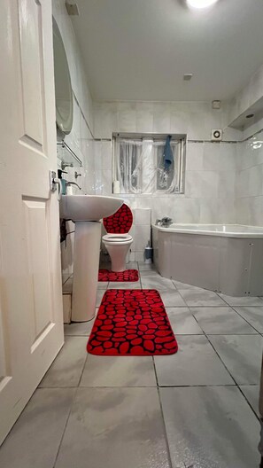 A bathroom with a toilet, sink, bathtub, and a shower area. - Room in House - Downtown Delight - Superior Double Room (Birmingham)