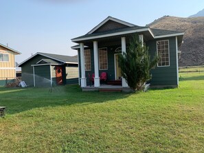 A single-story house with a front porch, a garage, and a well-maintained lawn. - Salmon Riverfront Home
Salmon, Challis & Gold Bug.  Fishing from back yard. (Salmon)