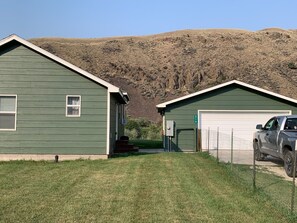 A green building with a garage and a truck parked in front. - Salmon Riverfront Home
Salmon, Challis & Gold Bug.  Fishing from back yard. (Salmon)