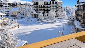 A snow-covered resort with multiple buildings, a central clock tower, and a clear sky. - RL 419 - High-Elevation Renovated Summer Escape in Prime Village Spot (Snowshoe)