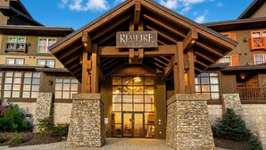 A lodge with a prominent sign reading 'RIMFIRE LODGE,' stone pillars, and a large entrance. - RL 419 - High-Elevation Renovated Summer Escape in Prime Village Spot (Snowshoe)