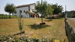 A white building with a tiled roof, surrounded by a grassy area with trees and a wooden fence. - APEZAINEA - SARE - Gîte (SARE)