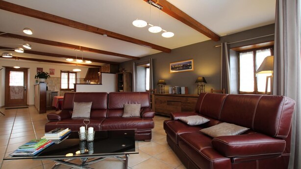 A spacious living room with a leather sofa, a glass coffee table, and a dining area in the background. - APEZAINEA - SARE - Gîte (SARE)
