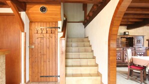 Una escalera de madera que lleva a una habitación con un reloj en la pared.