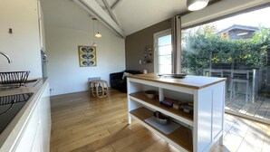 Eine moderne Küche mit Holztresen, einer eingebauten Spüle und einem großen Fenster mit Blick auf einen Garten.