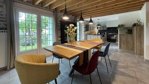 A modern dining area with a wooden table, chairs, and pendant lights. - Maison Mado-lily - Bidos (BIDOS)