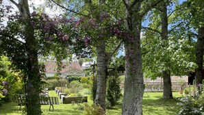 A garden with trees, flowers, and a gazebo. - Maison Mado-lily - Bidos (BIDOS)