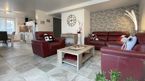 A modern living room with leather sofas, a coffee table, and a kitchen in the background. - Uharte Beherea - Souraide (SOURAIDE)